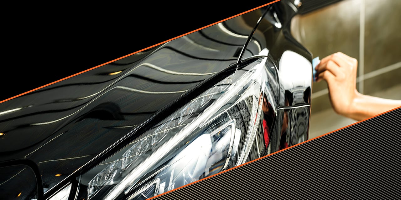 Hand polishing automobile bumper.