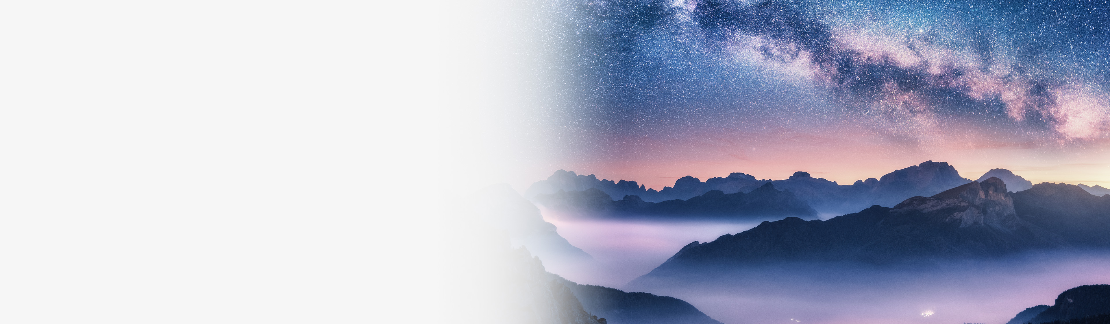 Milky Way over mountains and misty valleys at dawn under a starry sky.